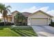 Tan one-story house with a two-car garage and lush landscaping at 3407 Fox Squirrel Ln, Valrico, FL 33594