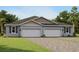 Two-car garage, gray exterior, and a nicely landscaped lawn at 6092 Timberdale Ave, Wesley Chapel, FL 33545