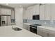 Modern kitchen with stainless steel appliances and grey cabinets at 6092 Timberdale Ave, Wesley Chapel, FL 33545