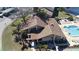 View of pool, and tennis court, surrounded by lush landscaping and serene lake at 3840 Staysail Ln # 3840, Holiday, FL 34691