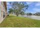 Backyard oasis with pond view, lush grass, and large tree at 3840 Staysail Ln # 3840, Holiday, FL 34691
