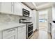 Modern kitchen with white cabinets, stainless steel appliances, and marble backsplash at 5875 21St N St # 15L, St Petersburg, FL 33714