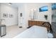 Bright bathroom with white tile flooring, wooden vanity, white countertops, and a soaking tub at 1100 Monterey Ne Blvd, St Petersburg, FL 33704