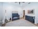 Bedroom with wood floors, white and grey rug, a grey crib, and a dresser with changing table at 1100 Monterey Ne Blvd, St Petersburg, FL 33704