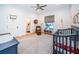 Bedroom with wood floors, unique rug, a grey crib, and a dresser with changing table at 1100 Monterey Ne Blvd, St Petersburg, FL 33704