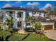 Beautiful two-story home featuring an arched entryway, lush landscaping, a two-car garage, and a dark metal roof at 1100 Monterey Ne Blvd, St Petersburg, FL 33704