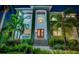 Elegant entryway with double doors, a chandelier, and lush landscaping creating a welcoming entrance to this home at 1100 Monterey Ne Blvd, St Petersburg, FL 33704