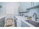 Laundry room with front load washer and dryer and gray cabinets and countertop at 1100 Monterey Ne Blvd, St Petersburg, FL 33704