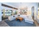 Bright, open living room with floor-to-ceiling windows, a waterfront view, modern furnishings, and access to the kitchen at 1100 Monterey Ne Blvd, St Petersburg, FL 33704