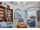 Open-concept living room with hardwood floors, a cozy seating area, an arched entryway, and a view of the dining room at 1100 Monterey Ne Blvd, St Petersburg, FL 33704