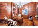 Home office with custom wood paneling, built-in shelves, and a large executive desk at 1100 Monterey Ne Blvd, St Petersburg, FL 33704