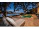 Backyard pool at night with waterfront views, lounge seating, and mature trees at 1100 Monterey Ne Blvd, St Petersburg, FL 33704