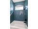 Bathroom shower and tub surrounded by attractive blue tile and a black shower head at 1100 Monterey Ne Blvd, St Petersburg, FL 33704