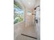 Walk-in shower with gray tile, black fixtures, and a large window with views of the water at 1100 Monterey Ne Blvd, St Petersburg, FL 33704
