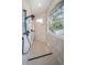 Walk-in shower with gray tile, black fixtures, and a large window with views of the water at 1100 Monterey Ne Blvd, St Petersburg, FL 33704