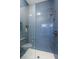 Modern shower with blue vertical tiles, built-in niche, glass door, and white shower floor at 1100 Monterey Ne Blvd, St Petersburg, FL 33704