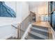 Modern staircase with carpeted steps, wood and metal railing, and stylish blue wall art at 1100 Monterey Ne Blvd, St Petersburg, FL 33704