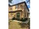Tan two-story townhome with brown accents, landscaping, and a two-car garage at 10235 Villa Palazzo Ct, Tampa, FL 33615