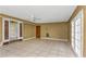 Large living room with tiled floors and multiple doors at 7620 Dennison Dr, Tampa, FL 33619