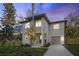 Modern house exterior at dusk with a paved driveway at 1919 E Hamilton Ave, Tampa, FL 33610