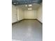 Spacious garage with light-grey epoxy floor and overhead door at 1919 E Hamilton Ave, Tampa, FL 33610