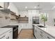 Modern kitchen with white cabinets, quartz countertops, and a large island at 1919 E Hamilton Ave, Tampa, FL 33610