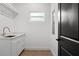 Functional laundry room with white cabinets and a sink at 1919 E Hamilton Ave, Tampa, FL 33610