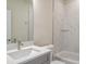 Clean bathroom with white vanity, marble shower, and a bathtub at 2509 Mario Way, Clearwater, FL 33761