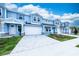 Two-story light blue townhome, white garage doors, paver driveway at 2509 Mario Way, Clearwater, FL 33761