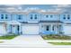 Three-unit townhome building, light blue exterior, white garage doors at 2509 Mario Way, Clearwater, FL 33761