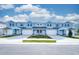 Three-unit townhome building, light blue exterior, white garage doors, paver driveways at 2509 Mario Way, Clearwater, FL 33761