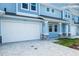 Two-story light blue home with white garage door and stone accents at 2509 Mario Way, Clearwater, FL 33761