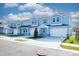 Light blue townhomes with white garage doors and landscaping at 2509 Mario Way, Clearwater, FL 33761