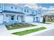 Two-story light blue townhome with white garage doors and landscaping at 2509 Mario Way, Clearwater, FL 33761