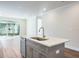 Modern kitchen island with sink, quartz countertop, and gray cabinets at 2509 Mario Way, Clearwater, FL 33761