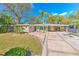 Mid-century modern home features a carport and well-manicured lawn at 8012 N Lynn Ave, Tampa, FL 33604