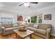 Living room with hardwood floors, neutral-toned sofas, and large windows at 860 25Th N Ave, St Petersburg, FL 33704