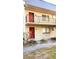 Two-story building with two units, red doors, and small yard at 11701 Raintree Village Blvd # C, Temple Terrace, FL 33617
