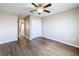 Bedroom with wood-look floors, access to hallway and ceiling fan at 12403 Ballentrae Forest Dr, Riverview, FL 33579