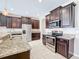 Modern kitchen with dark wood cabinets, granite countertops, and stainless steel appliances at 12403 Ballentrae Forest Dr, Riverview, FL 33579