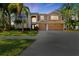 Two-story house with a three-car garage and palm trees in the front yard at 1858 Longview Ln, Tarpon Springs, FL 34689