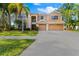 Two-story house with a three-car garage and palm trees in the front yard at 1858 Longview Ln, Tarpon Springs, FL 34689