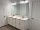 Spacious bathroom features double sinks with a quartz countertop, a large mirror, and modern fixtures at 31684 Griffin Sands Ln, San Antonio, FL 33576