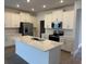 Modern kitchen features stainless steel appliances, a large island with quartz countertop, and white cabinetry at 31684 Griffin Sands Ln, San Antonio, FL 33576