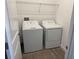 Functional laundry room with a washer, a dryer, tiled flooring, and a wire shelf at 31684 Griffin Sands Ln, San Antonio, FL 33576