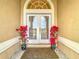 Front entry with double doors, arched window and red flowers at 4367 Burns Rd, Brooksville, FL 34602