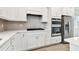 White kitchen with stainless steel appliances and hexagon tile backsplash at 9430 Shorebird Ct, Parrish, FL 34219