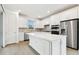 Modern kitchen with white cabinets, island, and stainless steel appliances at 9430 Shorebird Ct, Parrish, FL 34219