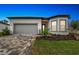 Single-story home with gray garage door and landscaping at 9433 Barnacle Ln, Parrish, FL 34219