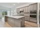 Modern kitchen featuring gray cabinets, quartz countertops, and island at 9433 Barnacle Ln, Parrish, FL 34219